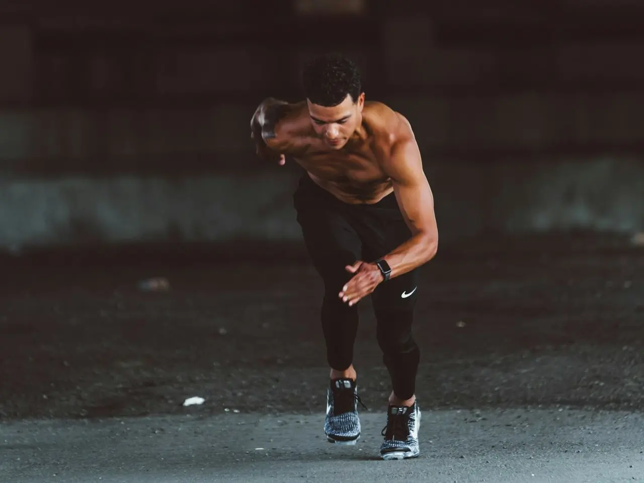 topless man in black pants and black shoes